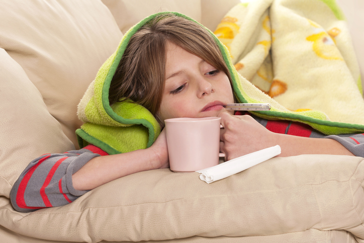 Bambino con influenza misura la febbre con termometro in bocca